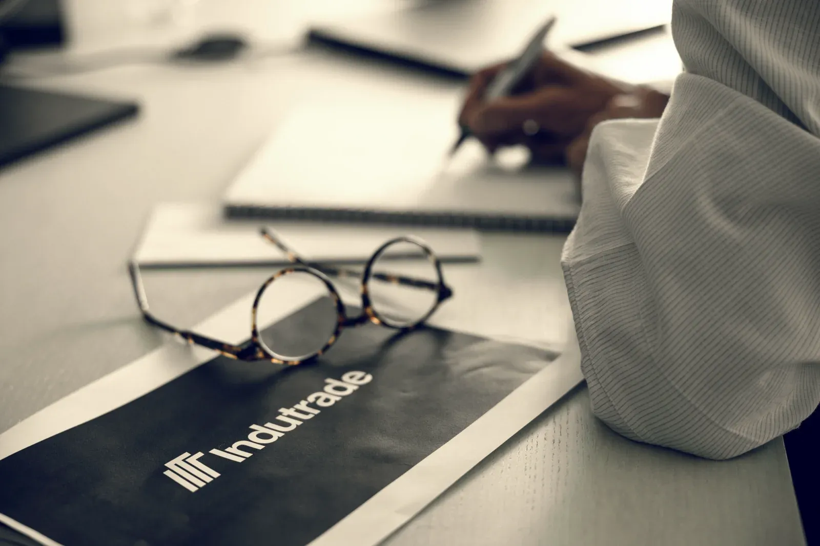 Indutrade Group printed literature on a desk beside a pair of glasses
